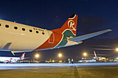Nairobi, Kenya - 26 August 2014: View of the tail of a Kenya Airways plane under the dim glow of airport lights, hinting at journeys ready to take flight.