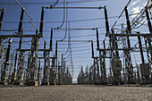 View of towering electrical infrastructure, a stark contrast against the clear blue sky, creating a geometric landscape of power, Suswa, Narok, Kenya.