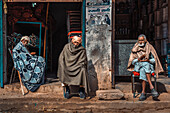 Kolkata, India - 28 January 2023: View of three elderly men, wrapped in shawls against the cold, sitting outside a shop, their weathered faces telling tales of time and tradition.