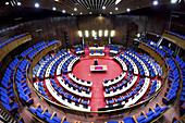 Freetown, Sierra Leone - 11 August 2021: View of the parliament building's interior, where blue seats contrast against the vivid red carpet, all bathed in the warm glow of overhead lights.