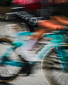 Paris, France - 27 July 2025: View of a blur of cyclists of the Tour de France 2025 speeding through the city, their vibrant jerseys a streak of color against the grey asphalt..