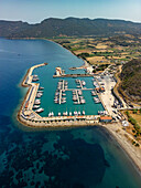 Luftaufnahme von Yachten im Yachthafen von Kormen, azurblaues Wasser trifft auf die zerklüftete Küstenlinie unter klarem Himmel, eine ruhige Szene, Datca, Mugla, Türkiye.