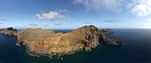 Aerial view of sun-kissed cliffs meet the deep blue sea, a panoramic vista of rugged beauty unfolds, contrasting earth tones against the vast ocean, Funchal, Madeira, Portugal.