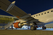 Nairobi, Kenya - 26 August 2014: View of the brilliant white and orange aircraft against the inky blue night sky, juxtaposed against the terminal building.