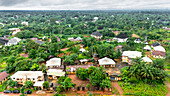 Aerial view of homes nestled amidst a sea of lush green trees, creating a tranquil and vibrant scene, Okwele Community, Imo State, Nigeria.