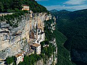 Aerial view of Santuario Madonna della Corona clinging to the cliffside, a beacon of faith against the rugged landscape, Madonna della Corona, Veneto, Italy.