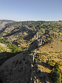 Luftaufnahme von sonnenverwöhnten Hängen und zerklüfteten Klippen, die auf einen klaren Himmel treffen und die Schönheit der Natur zeigen, Tannourine El Faouqa, North Governorate, Libanon.