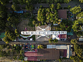 Aerial view of a white bridge structure amidst lush green trees and colorful buildings, a vibrant juxtaposition of nature and architecture, Yerevan, Yerevan, Armenia.