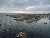 Aerial view of the rugged coastline, with its pink granite rocks contrasting against the deep blue sea, Perros-Guirec, Bretagne, France.