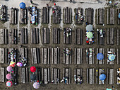 Aerial view of people enjoying outdoor dining at long wooden tables under colorful umbrellas at Campo Imperatore, Gran Sasso, Abruzzo, Italy.