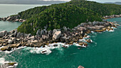 Luftaufnahme einer tropischen Insel, auf der smaragdfarbenes Wasser auf zerklüftete, felsige Küsten und grüne, dichte Wälder trifft, die die raue Schönheit der Natur zeigen, Paraty, Bundesstaat Rio de Janeiro, Brasilien.