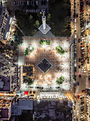 Aerial view of illuminated Piazza Square, a vibrant hub of activity with its intricate patterns and the iconic clock tower standing tall, Batumi, Adjara, Georgia.