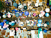 Aerial view of a bustling market scene unfolds with a vibrant tapestry of colorful umbrellas casting shadows on the ground, Kaduna, Kaduna, Nigeria.