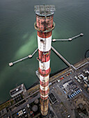 Luftaufnahme der Poolbeg Chimneys, deren rot-weiß gestreifter Anstrich sich deutlich vom stählernen Wasser der Dublin Bay abhebt, Dublin, Grafschaft Dublin, Irland.