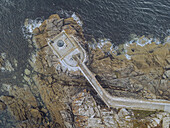 Aerial view of the Kermorvan Lighthouse standing defiant against the crashing waves, a beacon of hope on the rugged coastline, Le Conquet, Bretagne, France.