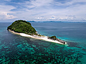 Luftaufnahme einer grünen Insel mit weißem Sand und türkisfarbenem Wasser, ein Juwel inmitten des weiten Ozeans, Romblon, Philippinen.