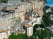 Aerial view of the Sanctuary of Madonna della Corona clinging dramatically to the sheer rock face, a beacon of faith amidst rugged beauty, Madonna della Corona, Veneto, Italy.