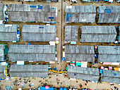 Aerial view of the market stalls casting long shadows in the bright sunlight, revealing the bustling activity below, Tudun Wada, Kaduna, Nigeria.