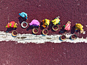 Plum, Bangladesh - 10 March 2024: Aerial view of a vibrant tapestry of deep red plums spread out to dry, punctuated by the colorful figures of women meticulously working along a bright white line.
