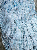 Luftaufnahme eines atemberaubenden Gletschers mit tiefblauen Gletscherspalten, die sich vom grauen Eis abheben und ein faszinierendes natürliches Muster bilden, Buarbreen-Gletscher, Odda, Norwegen.