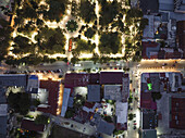Aerial view of the mesmerizing town square illuminated with warm lights contrasting against the deep blue twilight, showcasing the blend of nature and architecture, Kutaisi, Imereti, Georgia.