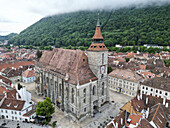 Luftaufnahme der historischen Biserica-Kirche, umgeben von malerischen Dächern und malerischen Bergen, Brasov, Brasov, Rumänien.