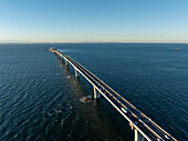 Luftaufnahme der Brücke über die Bucht von Tokio, die sich bei klarem Himmel über den ruhigen, dunkelblauen Ozean erstreckt, Nakajima, Chiba, Japan.