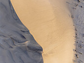 Aerial view of dune 7 with a man standing on the edge during sunset, Erongo, Namibia.