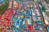 Bogura, Bangladesh - 09 February 2022: Aerial view of a bustling marketplace, a vibrant tapestry of colorful tents and stalls teeming with activity.