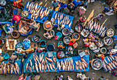 Bogura, Bangladesch - 18. November 2021: Luftaufnahme des pulsierenden Fischmarktes, auf dem silberne Schuppen vor blauen Planen und Erdtönen schimmern und das geschäftige Treiben von Handel und Gemeinschaft zu spüren ist.