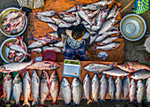 Bogura, Bangladesh - 18 November 2021: Aerial view of a vibrant fish market where silvery fish gleam against the earthy tones of the stall, creating a striking contrast.