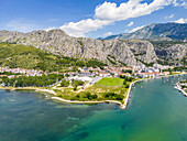 Luftaufnahme der türkisfarbenen Umarmung des Flusses Cetina mit der Adria, eingebettet in die schroffen, sonnenverwöhnten Klippen von Omis, Gespanschaft Split-Dalmatien, Kroatien.