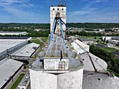 Luftaufnahme eines verwitterten Industrieaufzugs aus Beton, der sich von der Skyline abhebt. Seine gealterte Struktur steht im Kontrast zu dem entfernten Grün, Cincinnati, Ohio, Vereinigte Staaten.