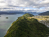 Luftaufnahme von Picton, Marlborough Region, Neuseeland, wo üppig grüne Hügel auf ruhiges, blaues Wasser treffen, das im Kontrast zu der übersichtlichen Anlage der Stadt steht.
