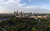 Aerial view of skyscrapers pierce the sky above a sea of green trees, contrasting the urban landscape with natural beauty, Charlotte, North Carolina, United States.