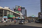 Kisumu, Kenya - 13 May 2021: View of the bustling Kisumu streets, where vibrant billboards tower above busy shops and the steady flow of traffic creates a lively urban scene.