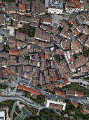 Aerial view of terracotta rooftops cascading down the hillside, a maze of narrow streets leading to open squares in the heart of town, Morcone, Benevento, Campania, Italy.