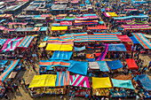 Bogura, Bangladesh - 09 February 2022: Aerial view of a bustling marketplace, a vibrant tapestry of colorful tarps and the hive of activity below, a sensory explosion of commerce and culture.
