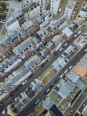 Aerial view of closely packed buildings and streets, a tapestry of slate roofs and brick facades under a soft, diffused light, Le Tréport, Normandy, France.