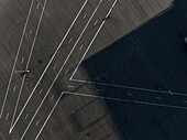 Concord, United States - 28 July 2025: Aerial view of the stark white lines dissecting the dark asphalt, creating geometric patterns under the long shadows at Charlotte Motor Speedway.