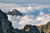 Aerial view of jagged peaks piercing through a sea of clouds, with the distinctive Hawrania mountain rising above the mist, Tatranská Javorina, Prešov Region, Slovakia.
