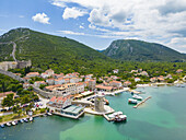 Aerial view of the quaint buildings nestled between the verdant hills and azure waters, with the historic walls snaking along the landscape, Mali Ston, Dubrovnik-Neretva County, Croatia.