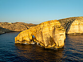 Aerial view of the majestic cliffs meet the deep blue sea creating a mesmerizing contrast of nature's raw beauty, Dwejra Cliffs, Gozo, Malta.