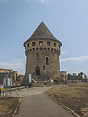 View of the majestic medieval Tour Tanguy stands tall against the clear blue sky, a stony sentinel overlooking the dry grassy landscape, Brest, Bretagne, France.