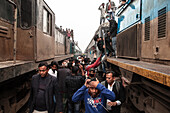Tongi, Bangladesh - 02 February 2025: View of crowded trains, a sea of faces amidst the carriages and rooftops, a symphony of human movement and metallic structures.