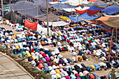 Tongi, Bangladesh - 31 January 2025: Aerial view of devoted worshippers kneeling in prayer under a patchwork of colorful tents, a sea of unity and faith.