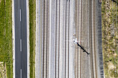 Aerial view of parallel lines of asphalt, railway track and grassy border create a geometric landscape from high above, Deutschlandsberg, Steiermark, Austria.