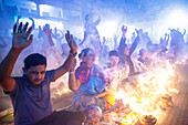 Narayanganj, Bangladesh - 09 November 2024: View of devotees with hands raised amidst the smoke and fire, a spectacle of faith and fervent devotion.