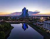 Hollywood, Florida, United States - 14 August 2025: Aerial view of the Seminole Hard Rock Hotel & Casino reflecting in the still waters under a pastel sky.