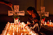 Chattogram, Bangladesh - 02 November 2022: View of a young girl's solemn vigil, lighting candles amidst the quiet stillness of a cemetery, the soft glow illuminating the crosses.
